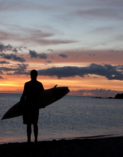 Surfing at sunset on Maui