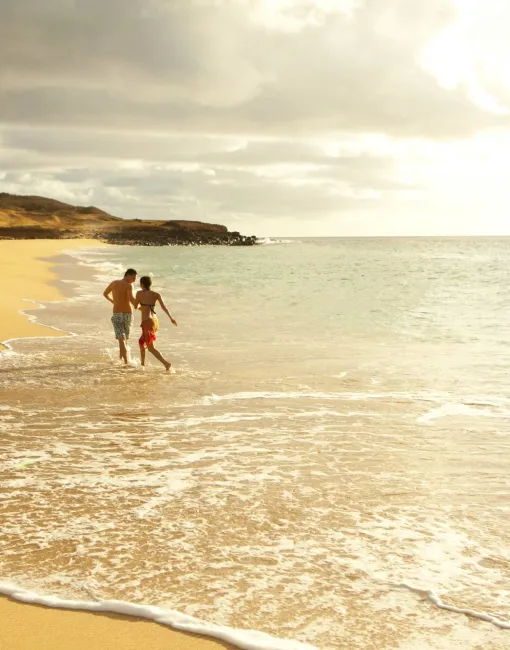 A couple walking on an empty beach on Molokai