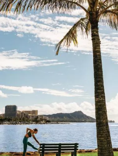 Woman stretching after run with Diamond head Oahu in background