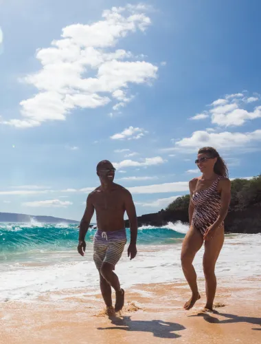 Couple walking down the shores of Mākena Beach on Maui in Hawaiʻi