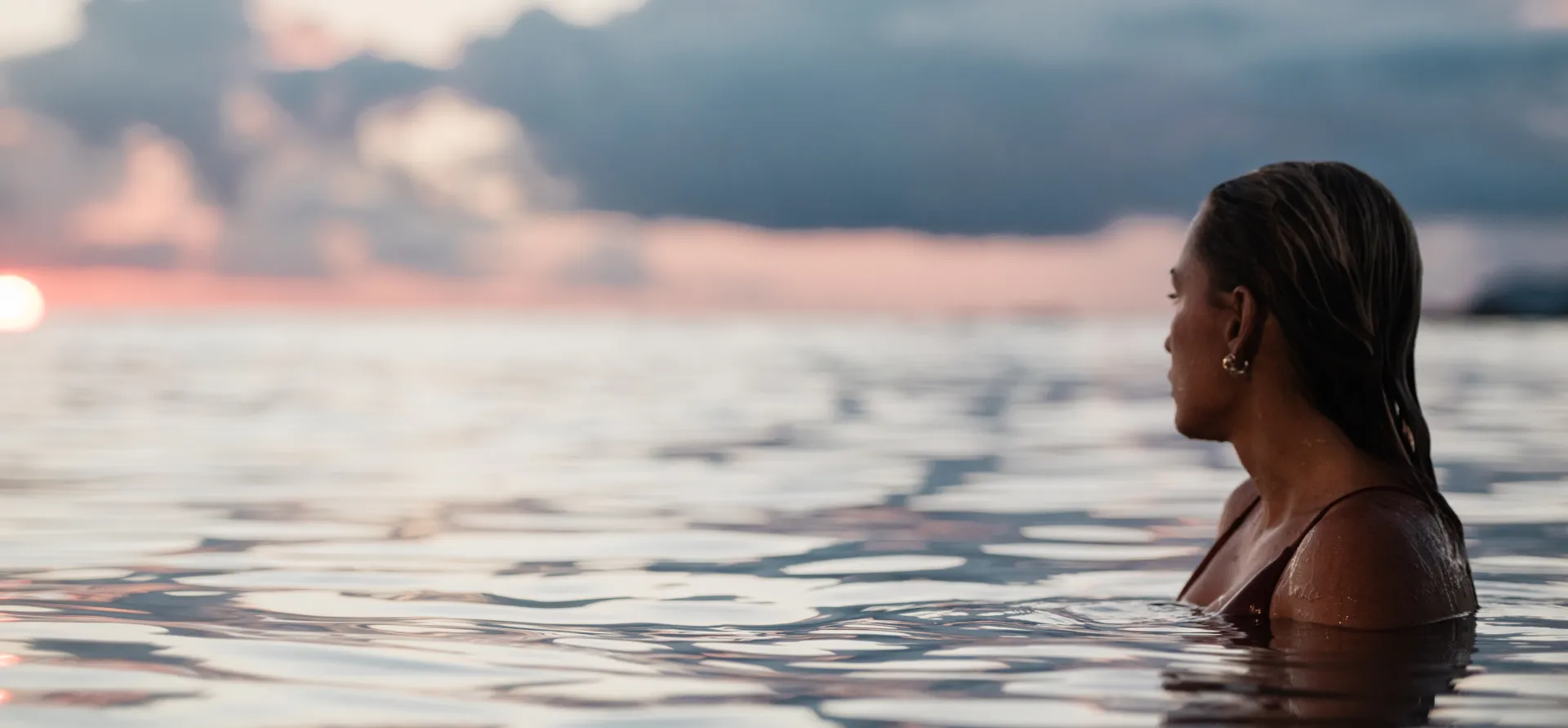 woman in ocean at sunset