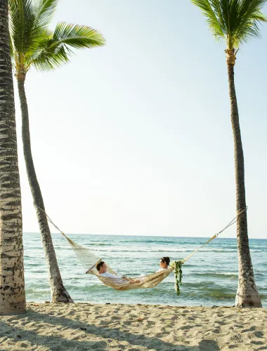 Newlywed couple in a hammock on a beach on the island of Hawaiʻi
