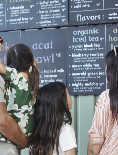 A family reading a menu at an Oahu restaurant