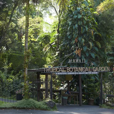 Entrance to the Hawaii Tropical Botanical Garden, surrounded by lush green plants and trees.