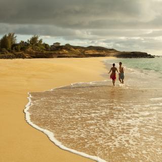 A couple on an empty beach in the west end of Molokai