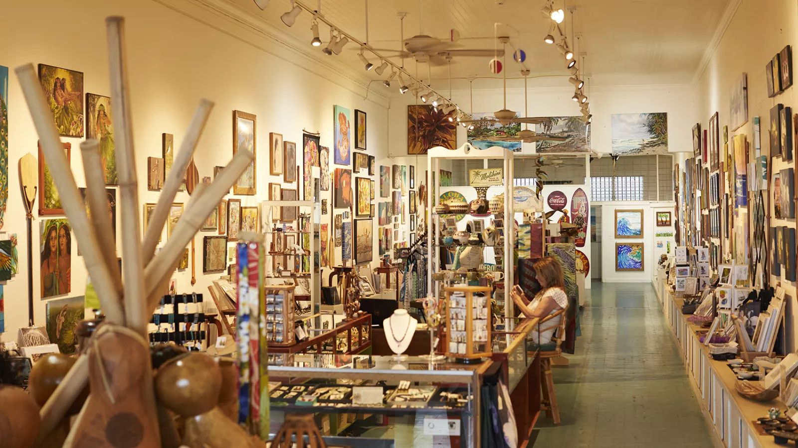 Inside an art gallery filled with local artwork, crafts, and jewelry displays.