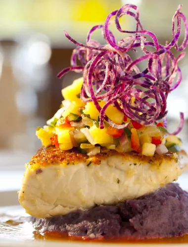 Artistically plated fine dining dish featuring fish and vegetables